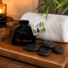 Hot rocks massage stenen met opbergzakje en productkaart op houten spa tray