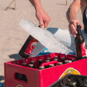 IJsblok bierkoeler voor 24 flesjes in krat, flesje uit ijsblok gehaald op strand