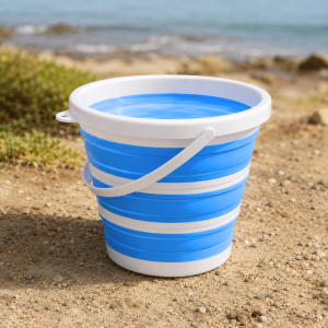 Blauwe opvouwbare emmer van 10 liter gevuld met water op een strand.