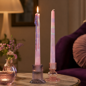 Rainbow drip kaarsen in glazen kandelaars op marmeren tafel met warme interieursetting
